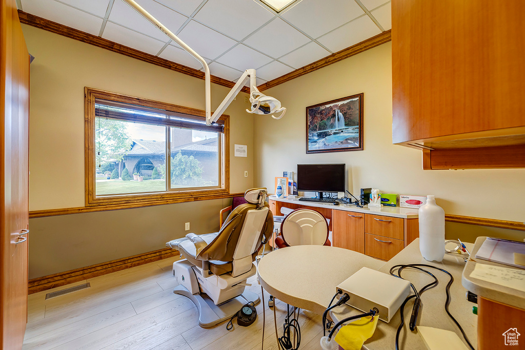 Office area with crown molding and light wood-style floors