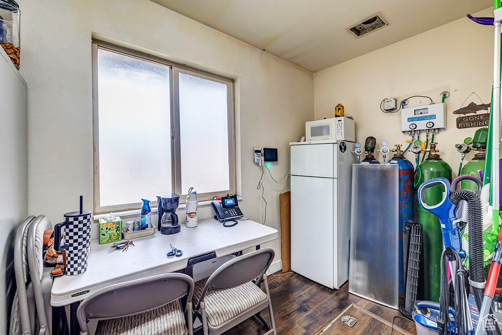 Kitchen with white appliances and dark wood-type flooring