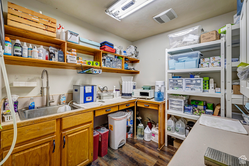 Kitchen with dark wood-style flooring, a sink, and open shelves