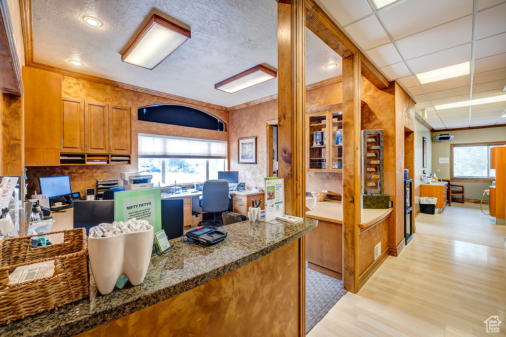 Kitchen featuring an office area, light wood-style flooring, brown cabinets, and ornamental molding