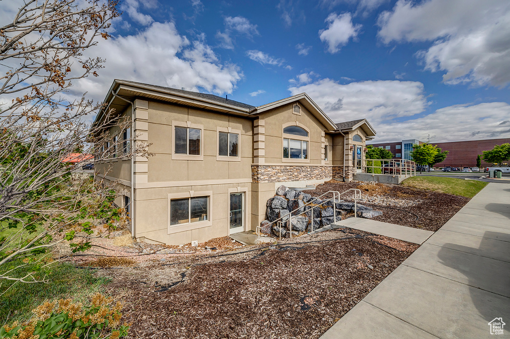 View of property exterior featuring stucco siding and stone siding