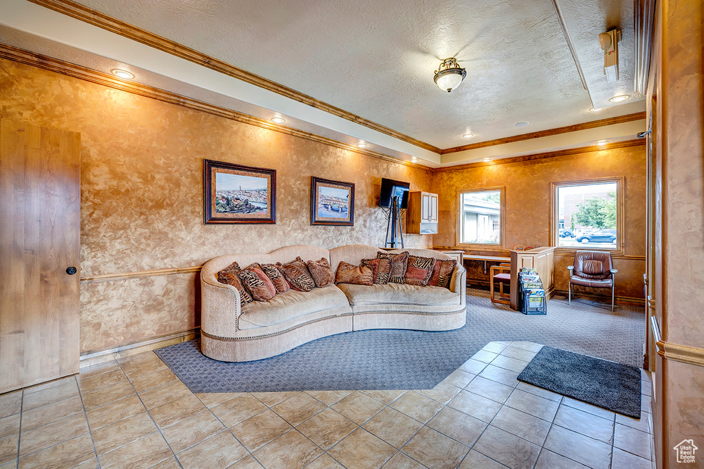 Tiled living area with a textured ceiling, crown molding, and baseboards