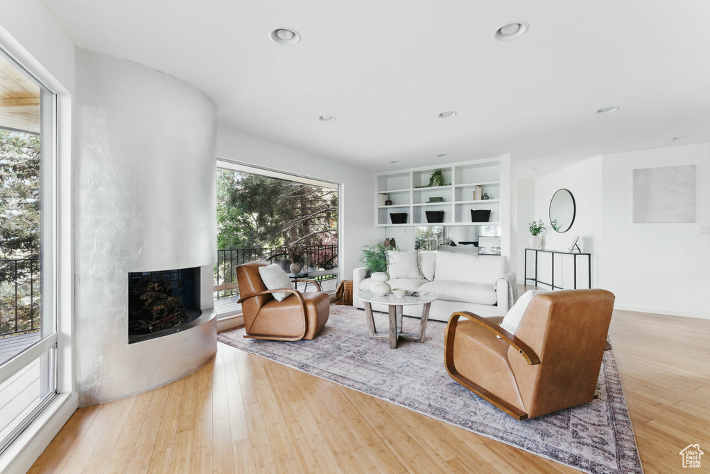 Living room with a fireplace, wood finished floors, and recessed lighting