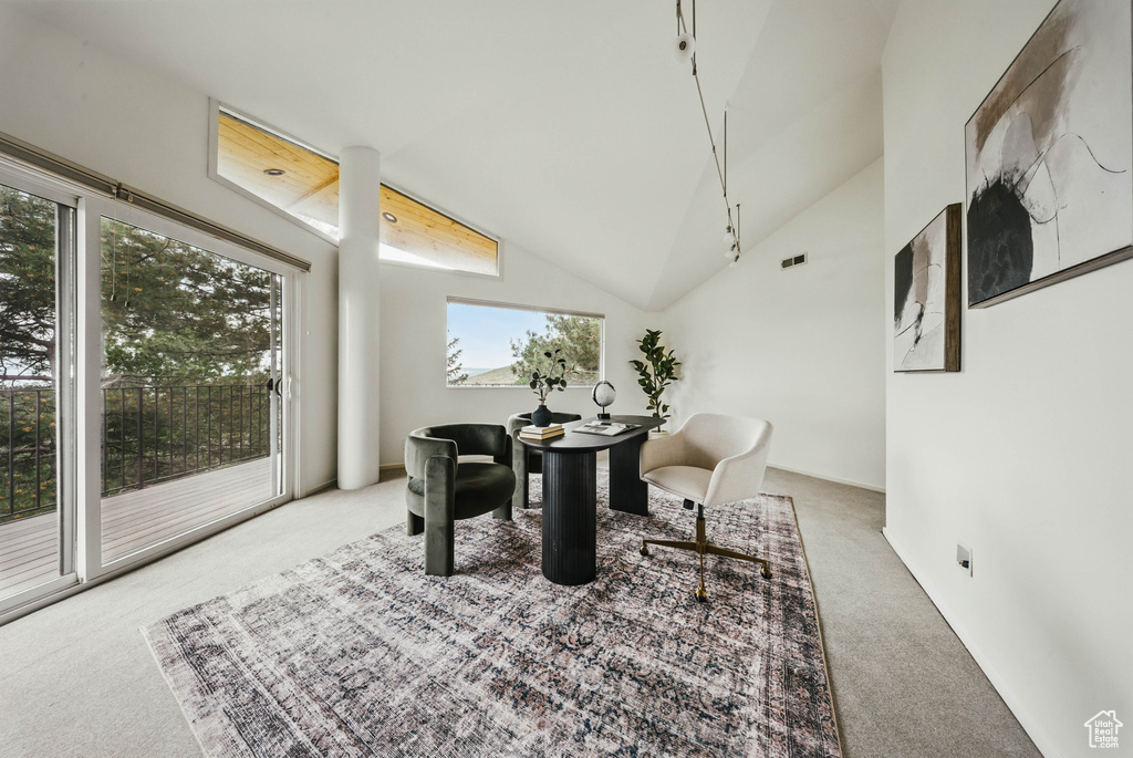 Carpeted dining area featuring vaulted ceiling