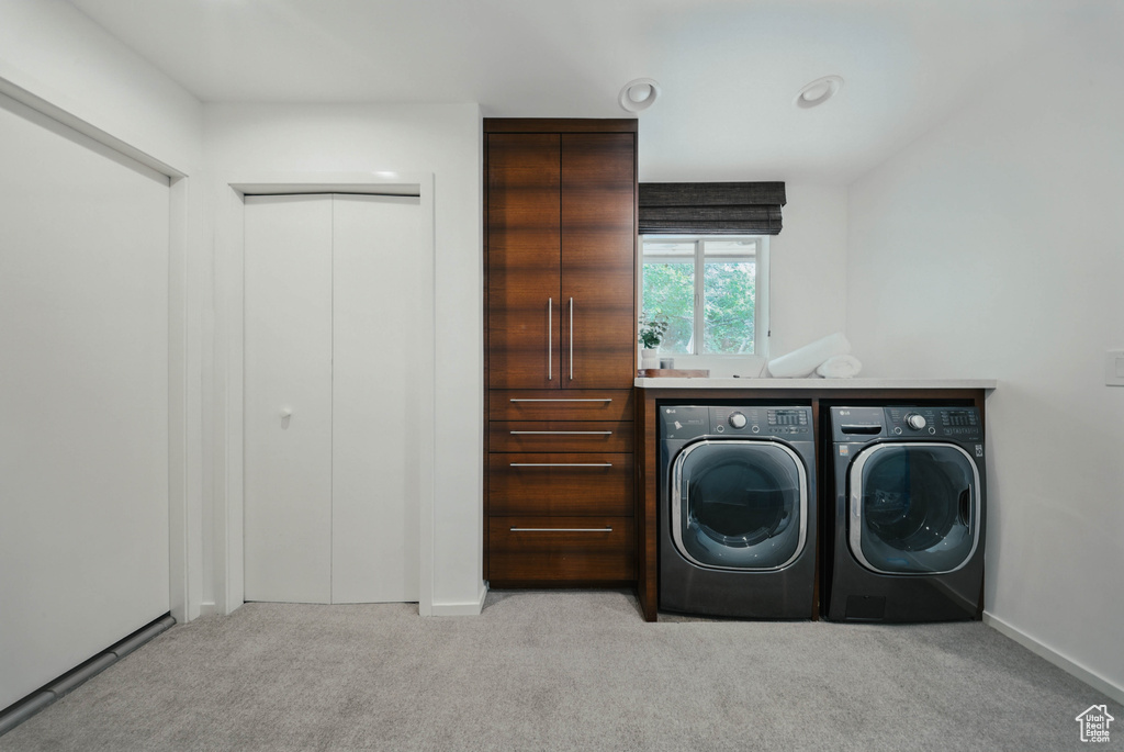 Washroom featuring washing machine and clothes dryer, carpet flooring, and baseboards