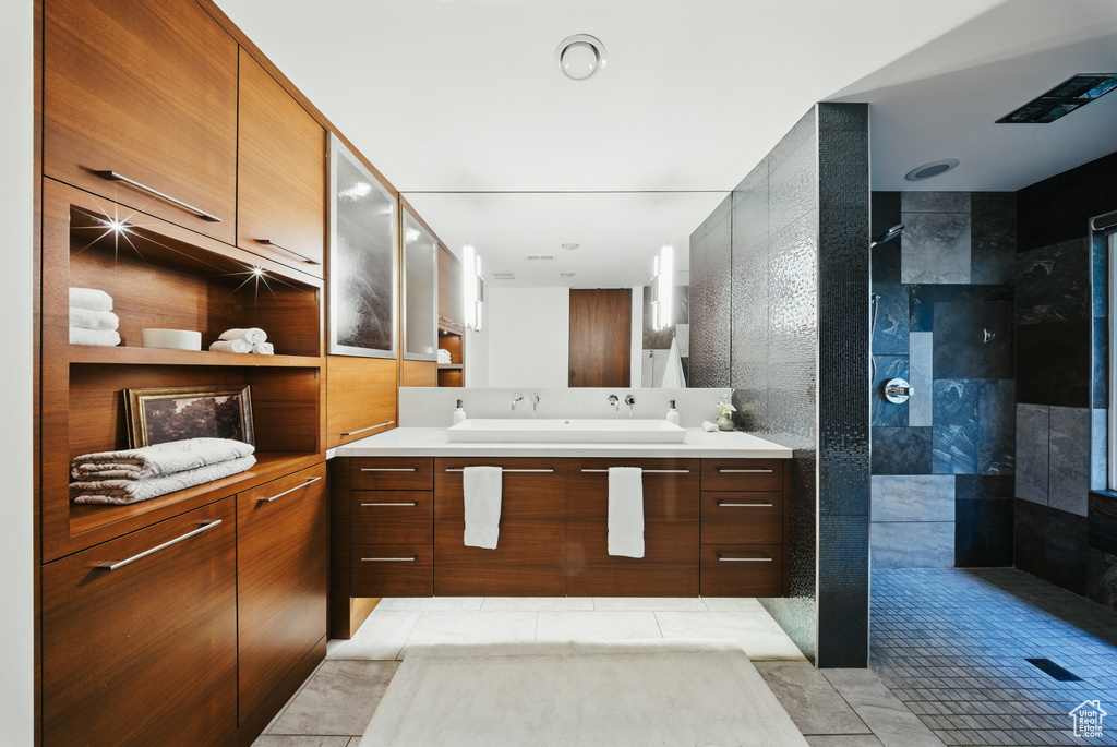 Full bathroom with walk in shower, vanity, and tile patterned flooring