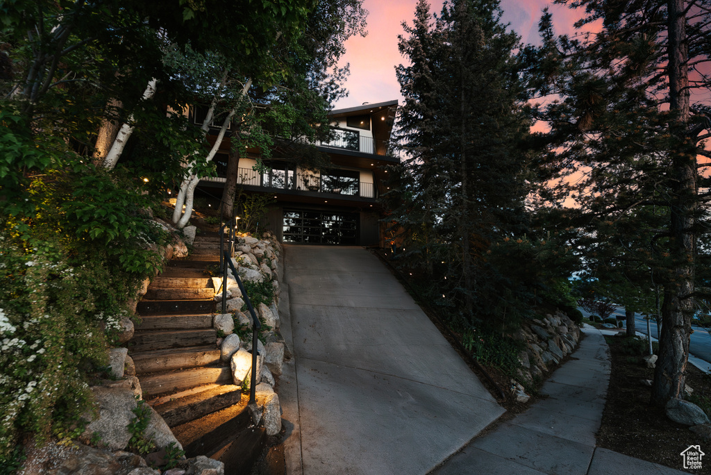 Obstructed view of property with concrete driveway, stairway, and a garage