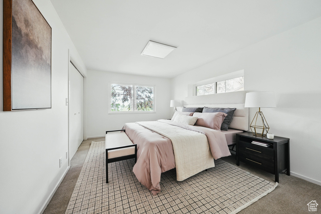 Bedroom with light colored carpet and baseboards