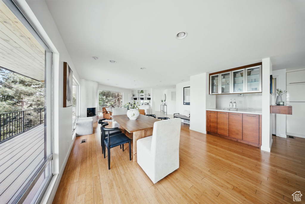 Dining space with light wood-type flooring, bar, and recessed lighting