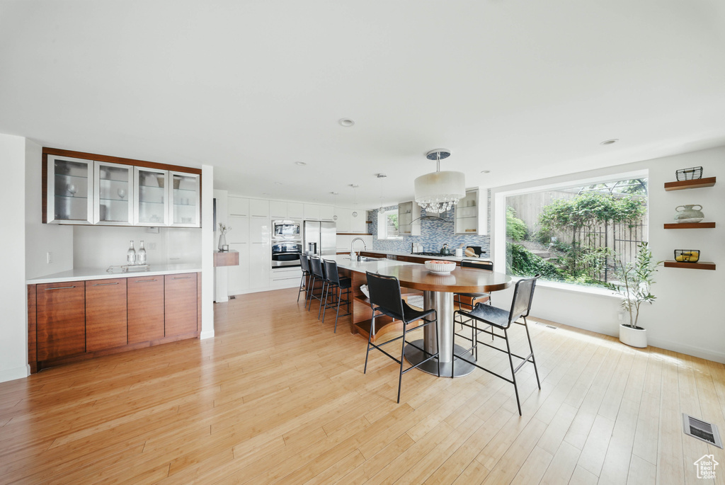 Dining room with light wood-type flooring, plenty of natural light, and recessed lighting