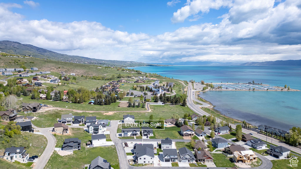 Aerial overview of property\'s location with a water and mountain view and nearby suburban area