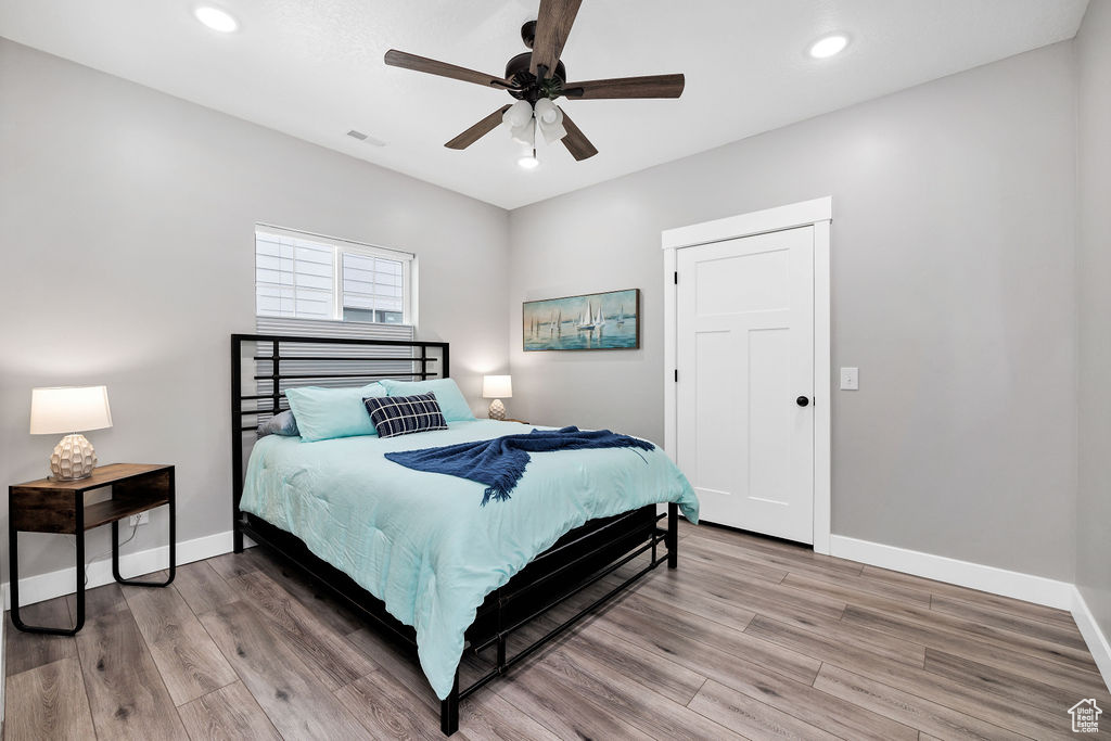 Bedroom with light wood-style floors, baseboards, recessed lighting, and a ceiling fan