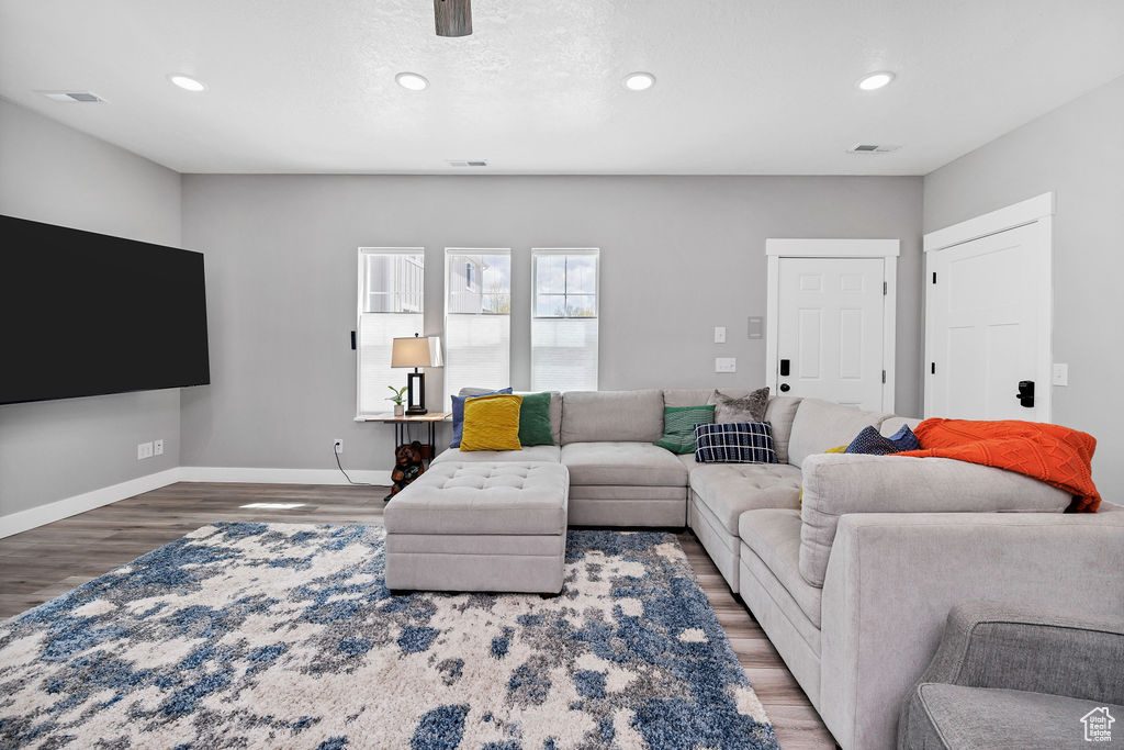 Living area featuring wood finished floors, recessed lighting, and baseboards
