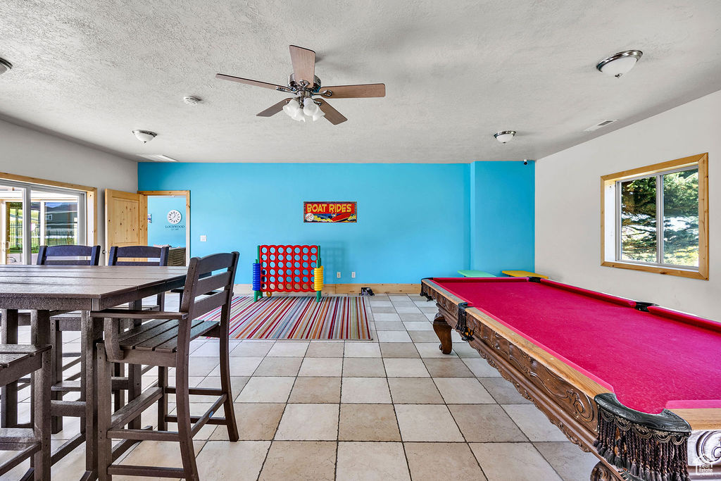 Playroom with ceiling fan, light tile patterned floors, billiards, and a textured ceiling