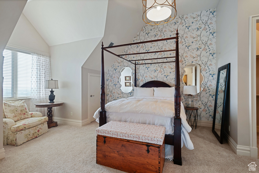 Carpeted bedroom featuring wallpapered walls, vaulted ceiling, and baseboards