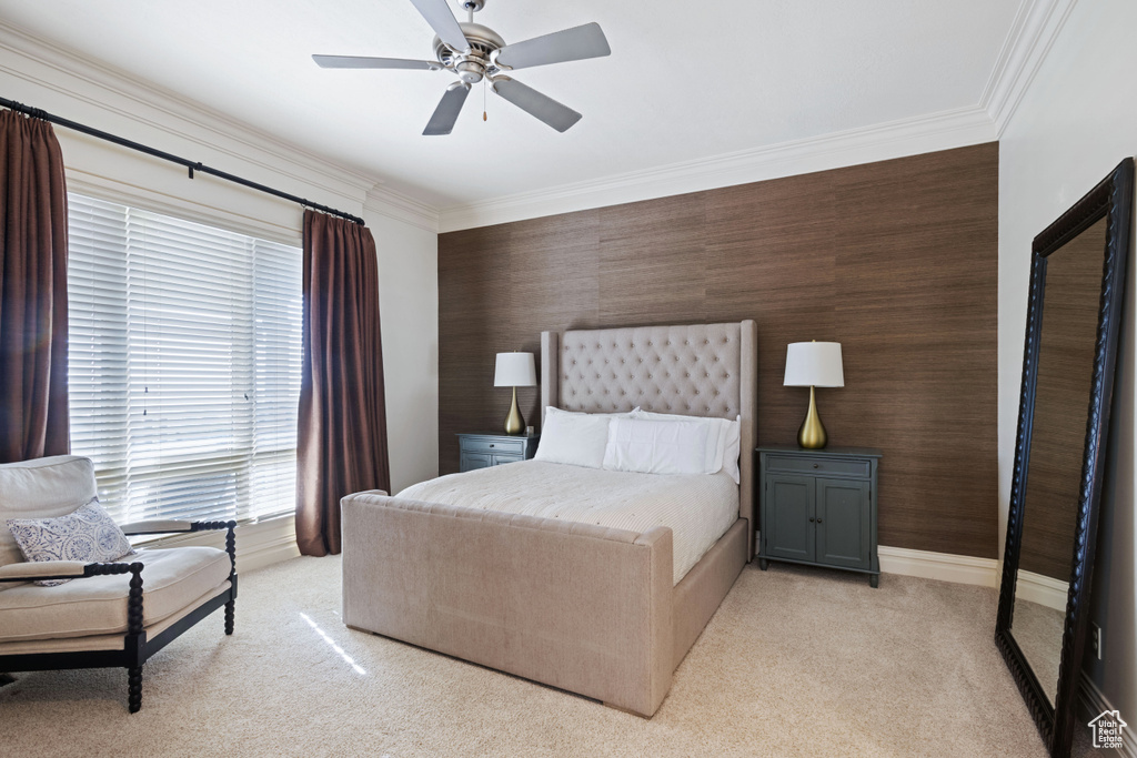 Bedroom with light carpet, ornamental molding, ceiling fan, and baseboards