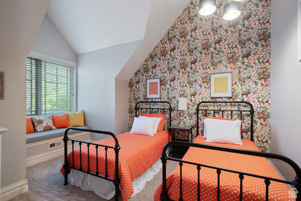 Carpeted bedroom featuring vaulted ceiling and baseboards