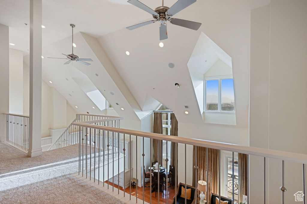 Corridor featuring high vaulted ceiling, an upstairs landing, a skylight, and recessed lighting