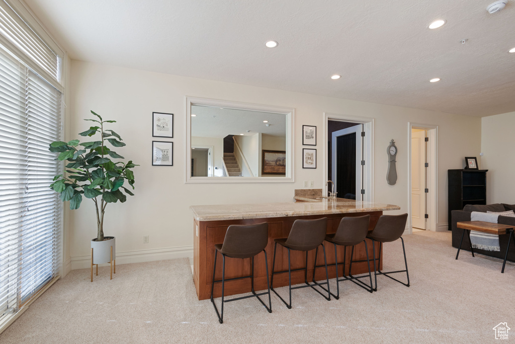 Indoor bar with light carpet, recessed lighting, and baseboards