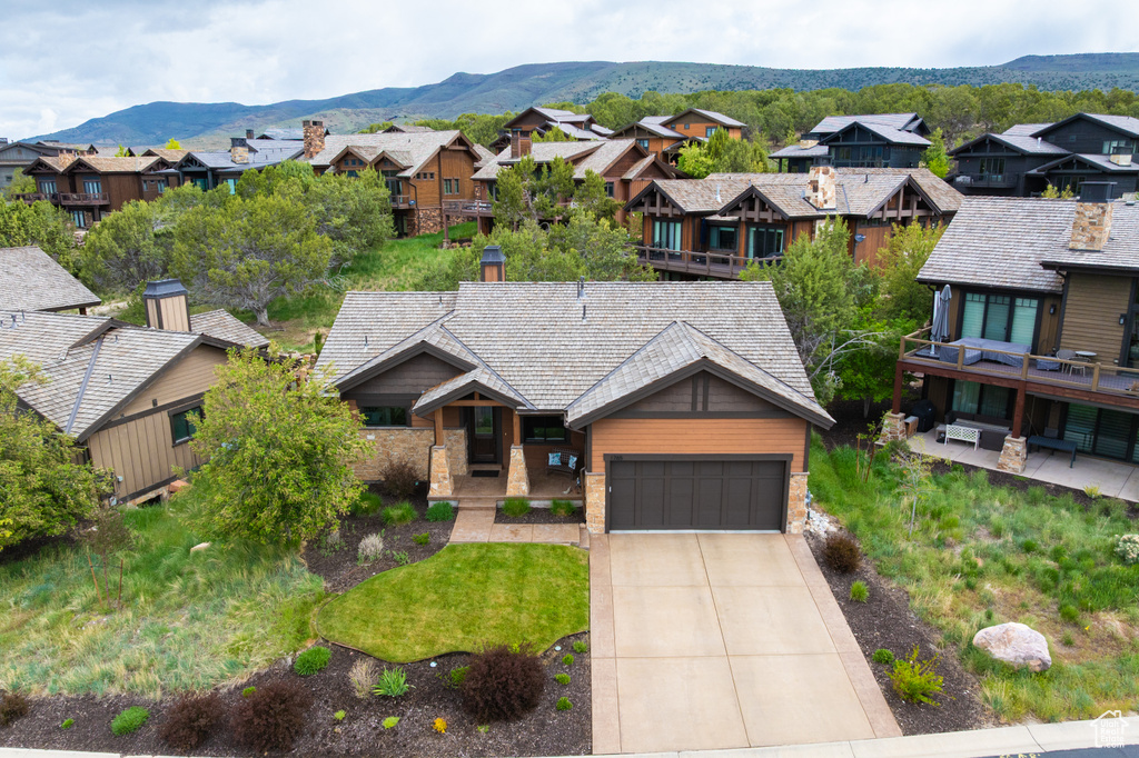 View of front facade with a residential view, driveway, a garage, and a mountain view