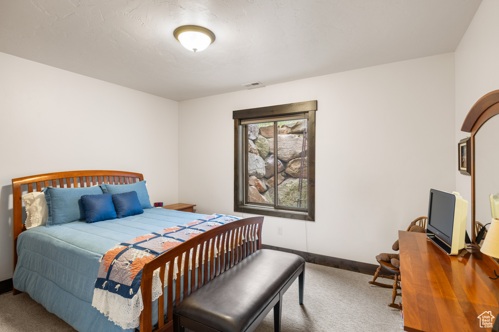 Bedroom featuring carpet floors and baseboards
