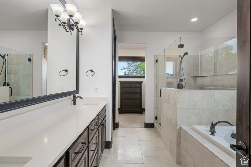 Bathroom with a shower stall, double vanity, a bath, tile patterned floors, and a chandelier