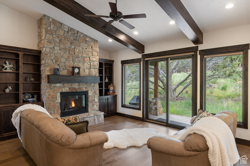 Living area with wood finished floors, baseboards, ceiling fan, a fireplace, and recessed lighting