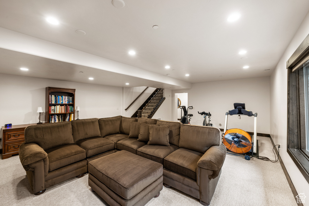 Living room with light carpet, recessed lighting, and stairs