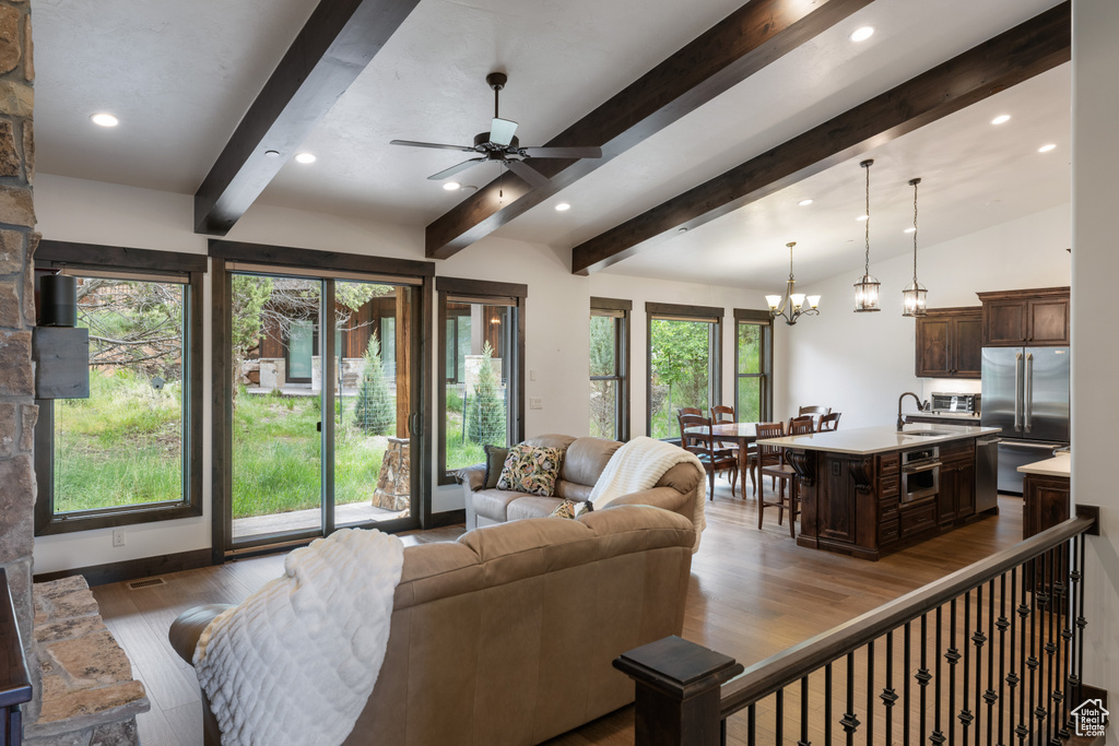 Living area featuring wood finished floors, recessed lighting, ceiling fan, and a chandelier