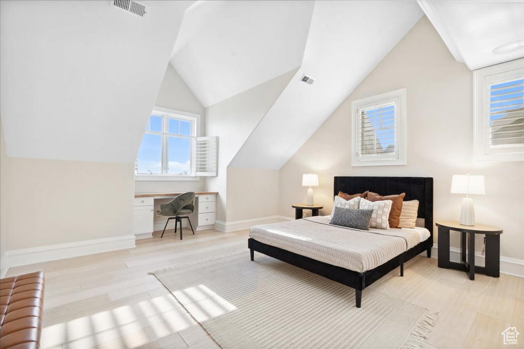 Bedroom with light wood-style flooring, vaulted ceiling, and baseboards