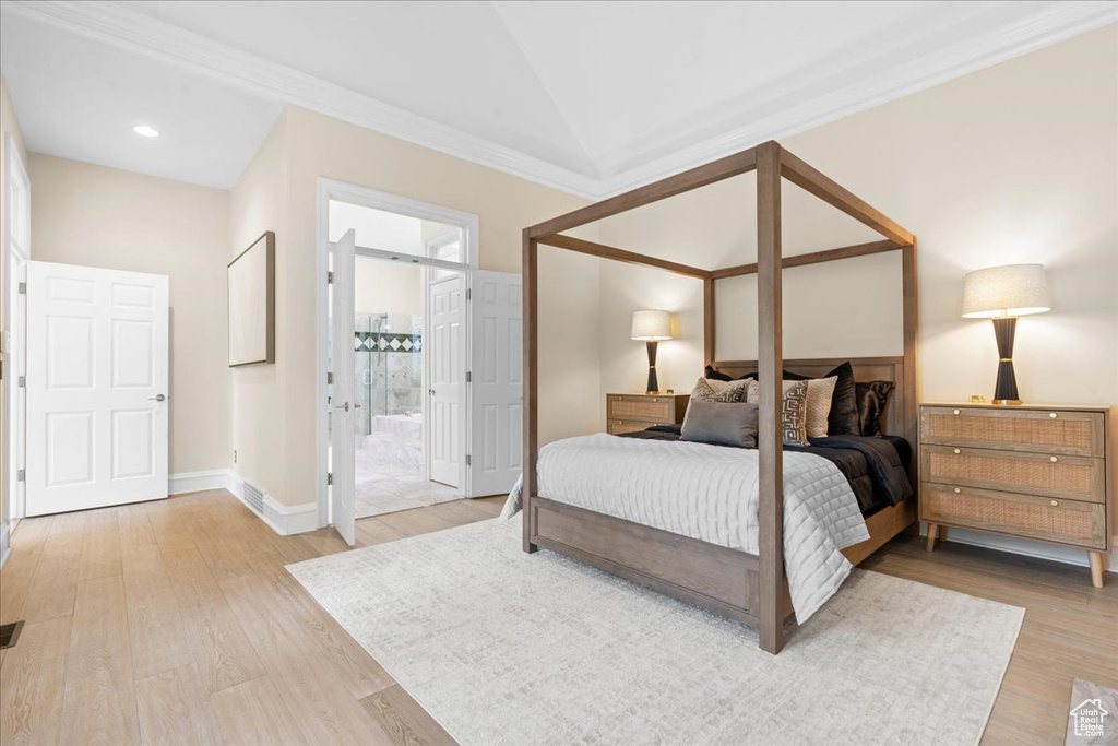 Bedroom with light wood-type flooring, connected bathroom, baseboards, and crown molding