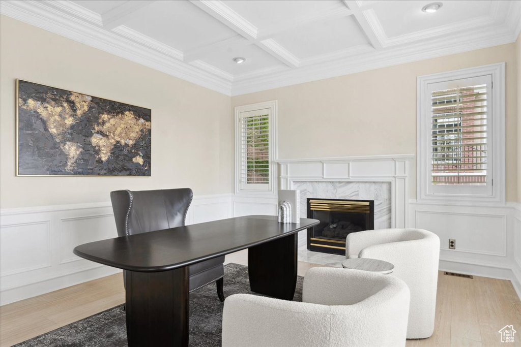 Office area with plenty of natural light, light wood-style flooring, coffered ceiling, beam ceiling, and a decorative wall