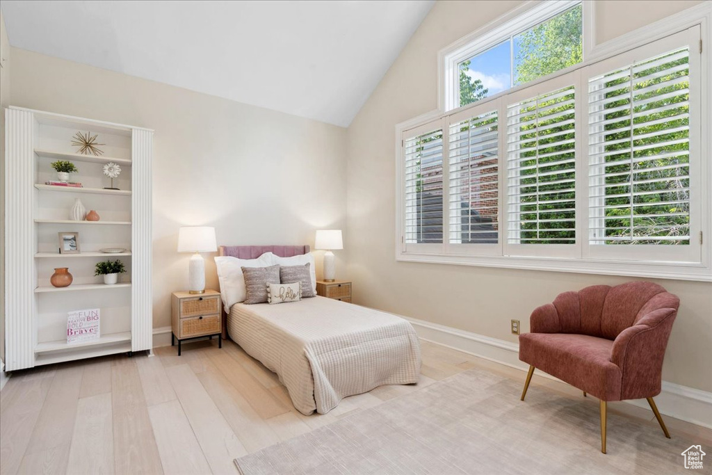 Bedroom with wood finished floors, baseboards, and lofted ceiling