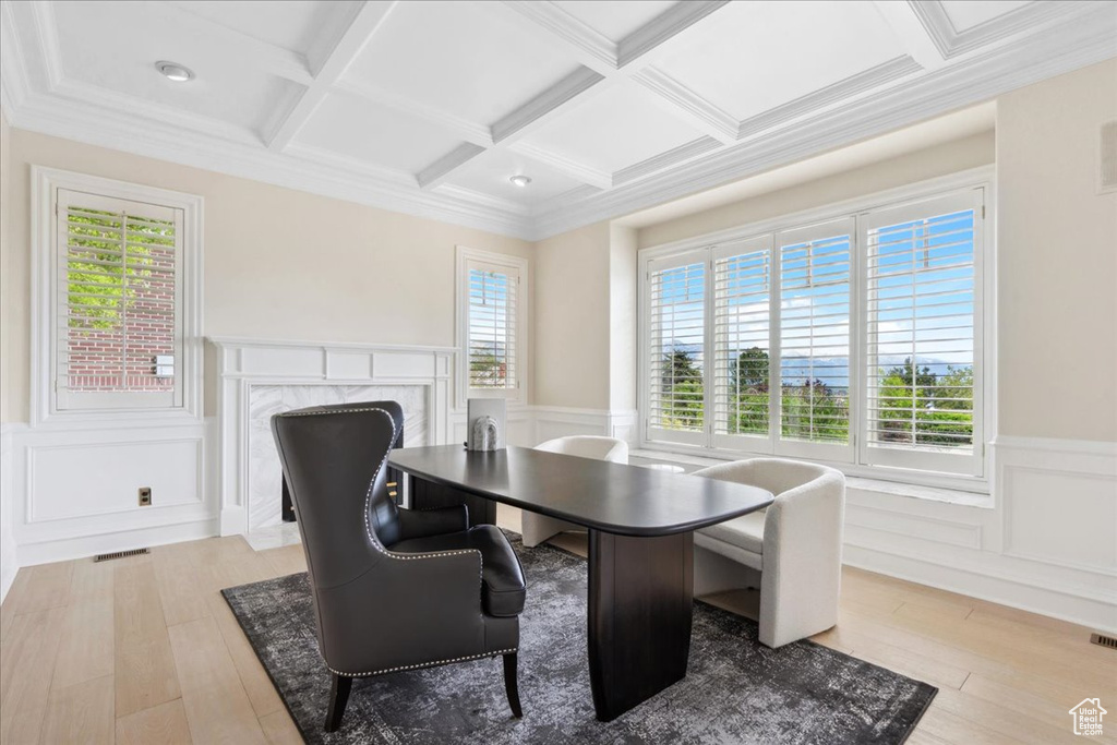 Dining area with coffered ceiling, wainscoting, healthy amount of natural light, a high end fireplace, and a decorative wall