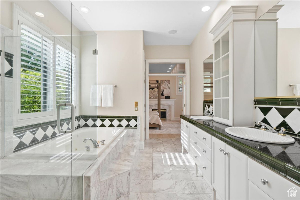 Bathroom with a garden tub, ensuite bathroom, vanity, a fireplace, and recessed lighting
