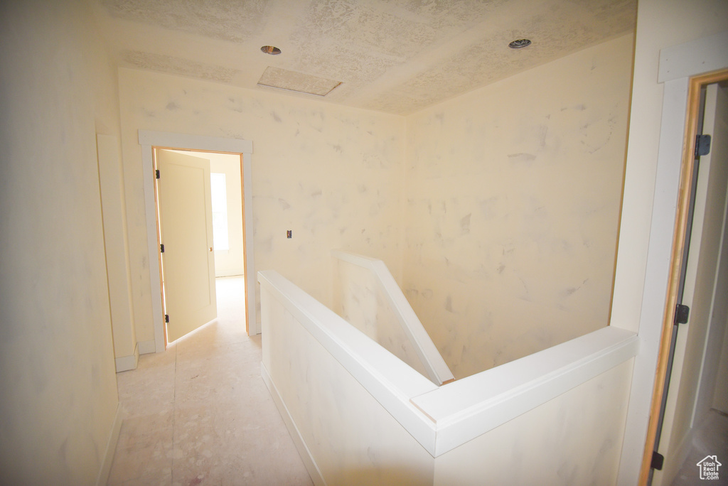 Hall featuring an upstairs landing and baseboards