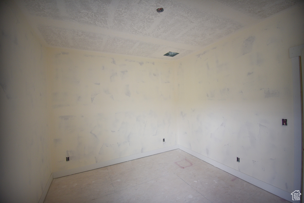 Spare room with baseboards and a textured ceiling