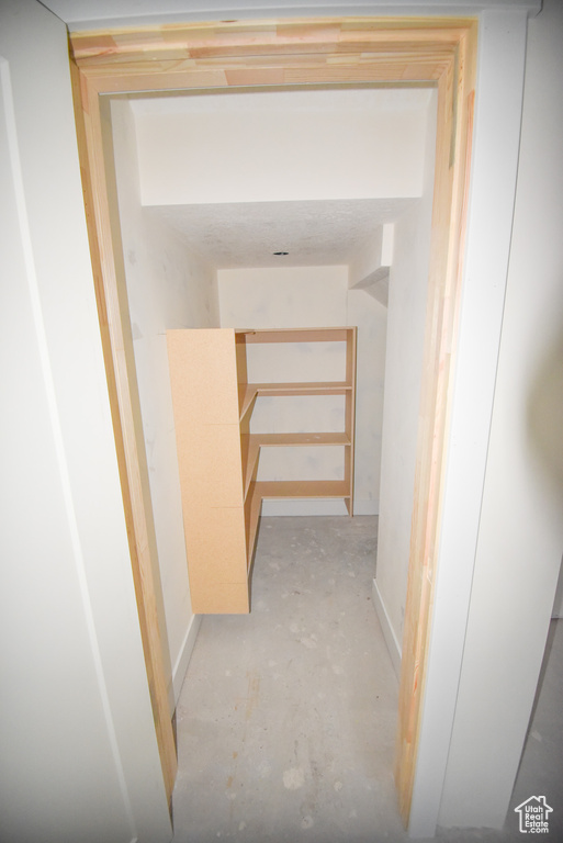Corridor featuring unfinished concrete flooring