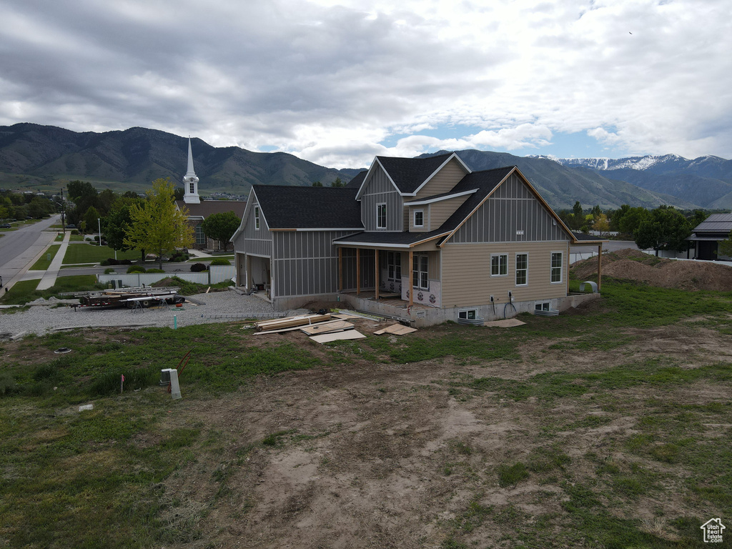Rear view of house featuring board and batten siding, a mountain view, and a porch