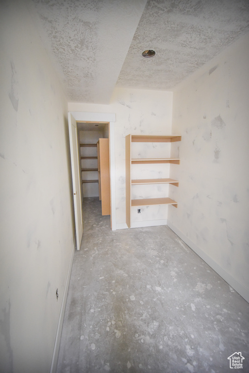 Empty room featuring unfinished concrete floors and baseboards