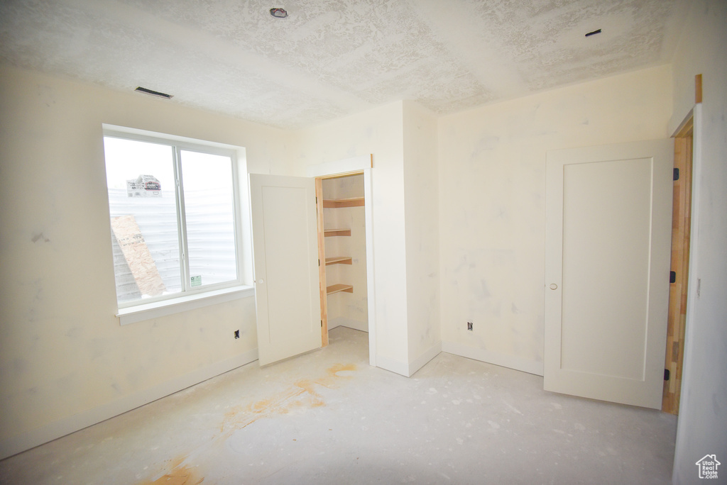 Unfurnished bedroom with a textured ceiling and baseboards