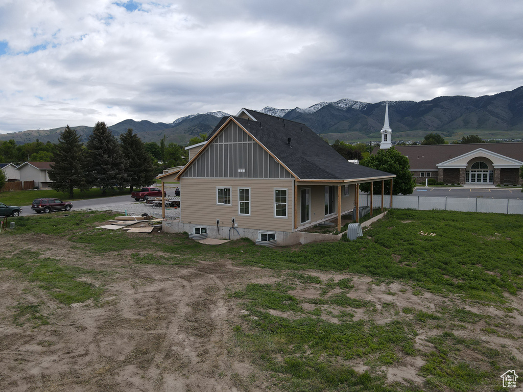 Back of house featuring a mountain view and board and batten siding