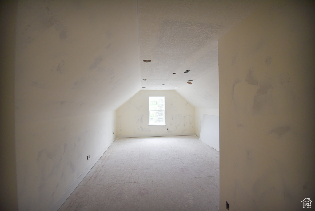 Bonus room featuring lofted ceiling and a textured ceiling