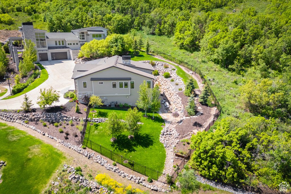 Aerial view of property and surrounding area featuring a forest