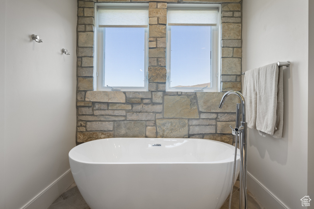 Bathroom featuring baseboards and a freestanding tub