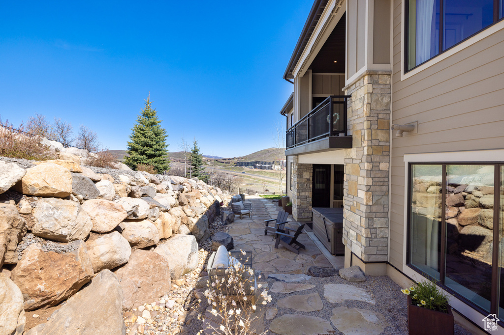 View of patio with a balcony and a mountain view