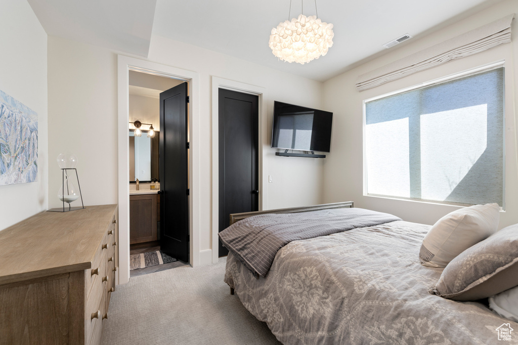 Bedroom featuring light carpet and a chandelier