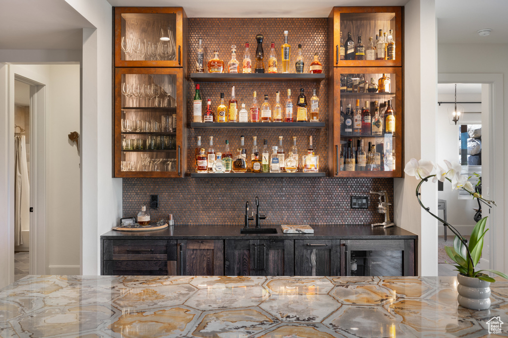 Indoor wet bar featuring tasteful backsplash and beverage cooler
