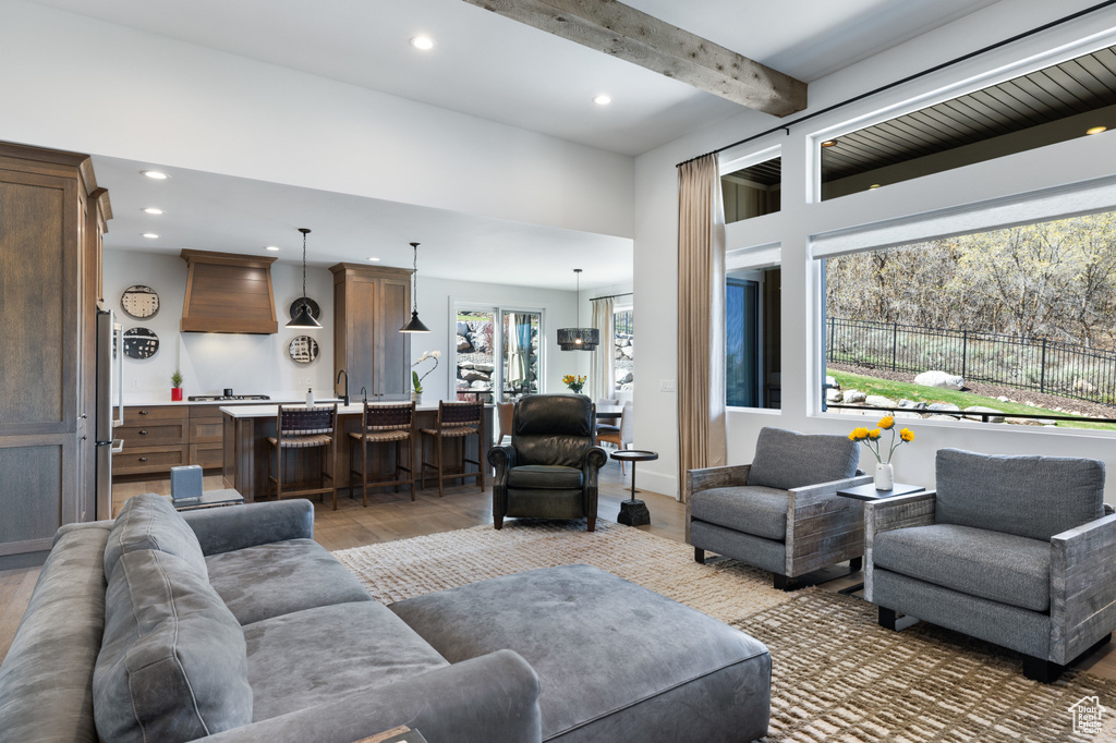 Living area featuring light wood finished floors, recessed lighting, and beam ceiling