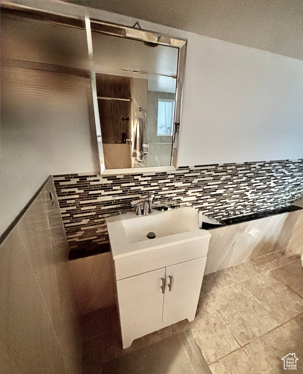 Bathroom featuring vanity, a shower, and decorative backsplash